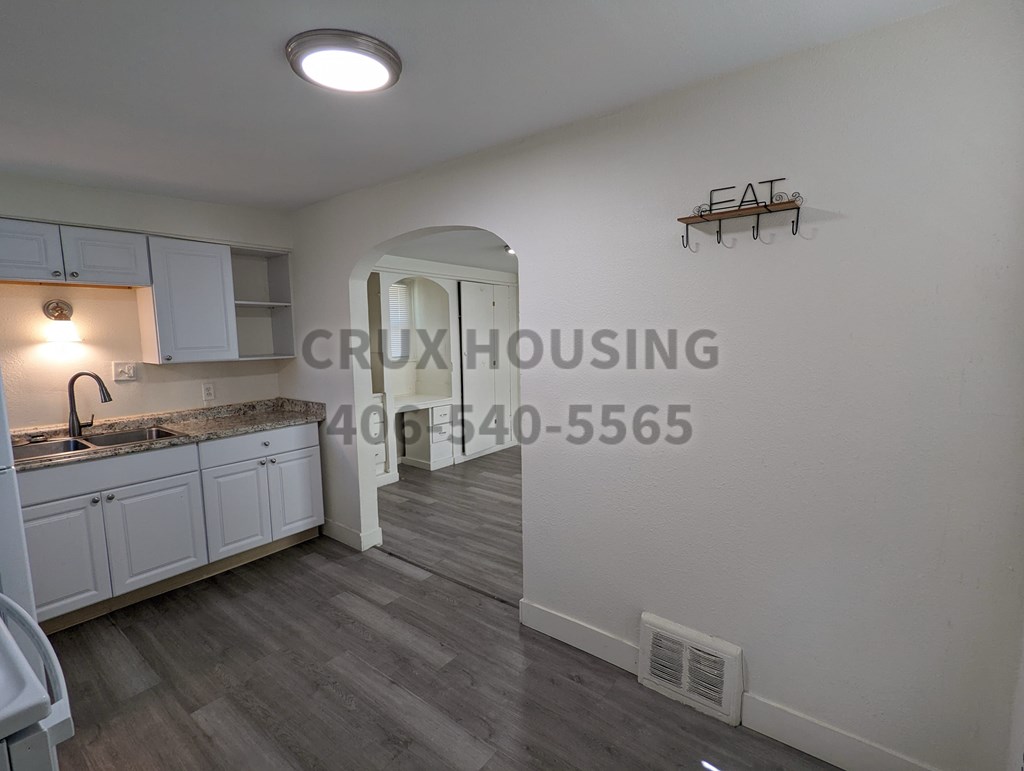 A kitchen with a sink and a counter with a light on.