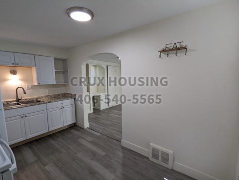 A kitchen with a sink and a counter with a light on.