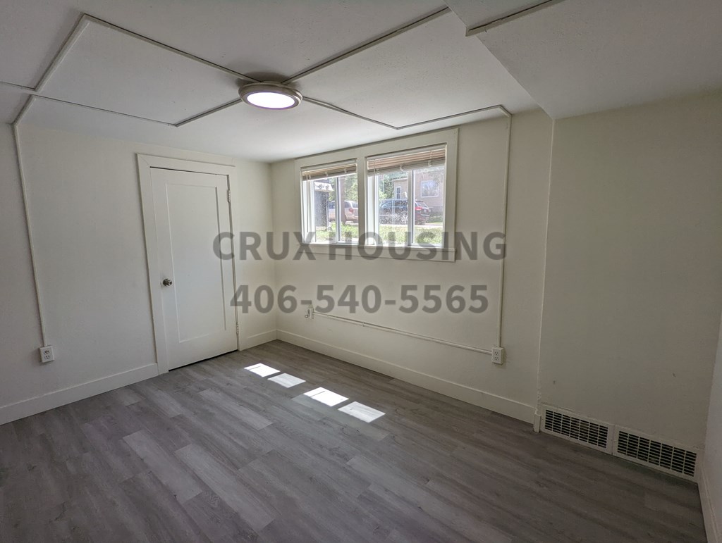 A room with a window and a door is available for rent.