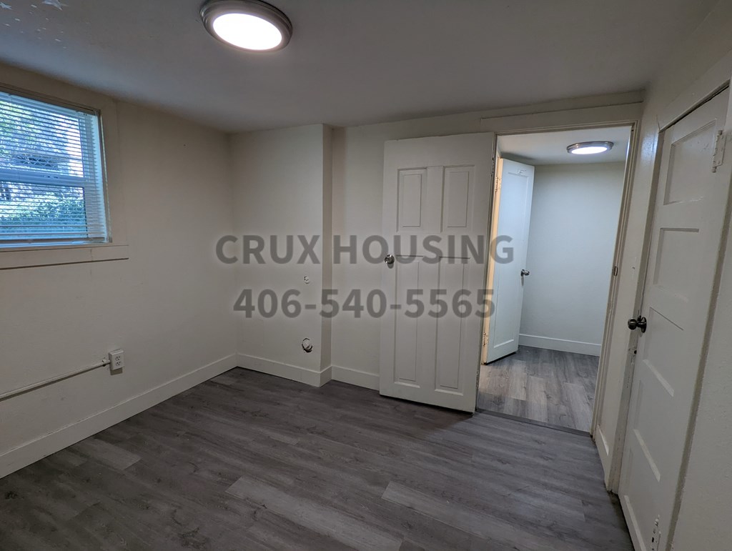 A room with a window and a door is available for rent.