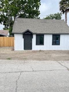 a small white house with a black door and