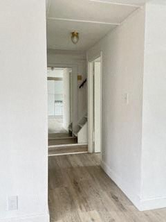 a hallway with white walls and a wood floor