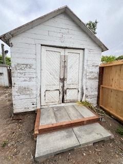 an old white building with doors and a wooden porch