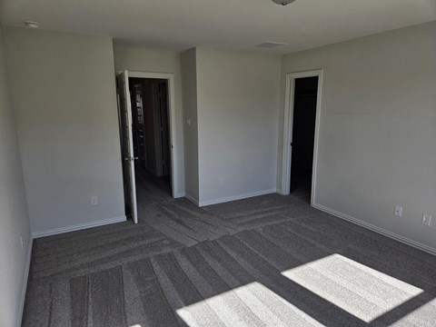a living room with grey carpet and white walls