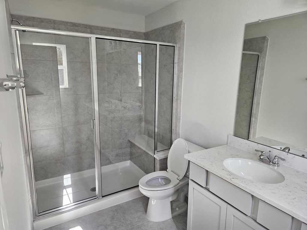 a bathroom with a shower and a sink and a toilet