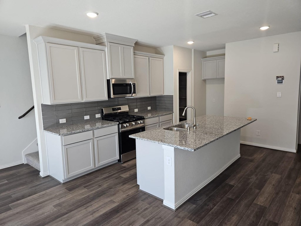 a kitchen with white cabinets and a counter top