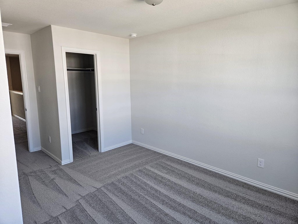 a empty room with a carpet and a door to a closet