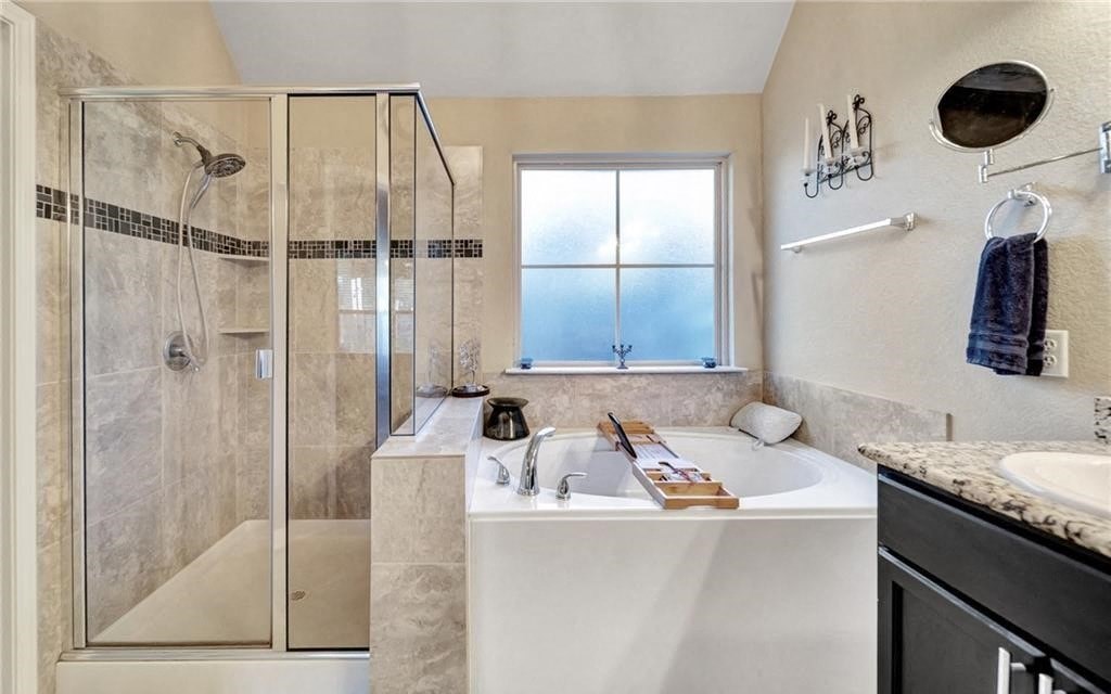 a bathroom with a tub and a shower and a sink