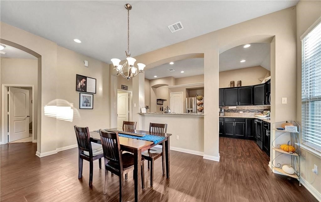 a dining room and kitchen with a table and chairs
