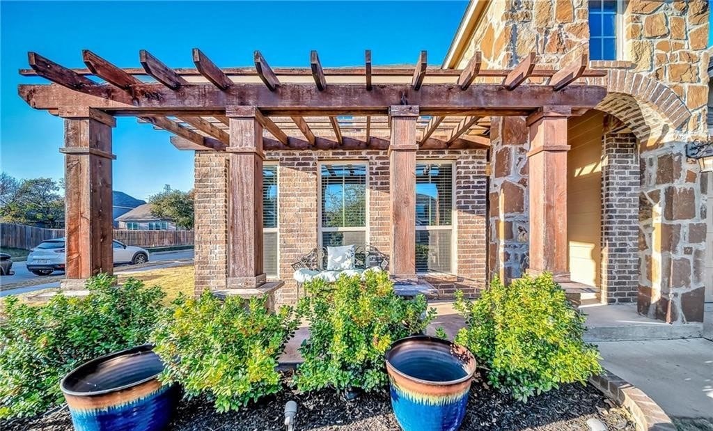 the front yard of a brick house with potted plants