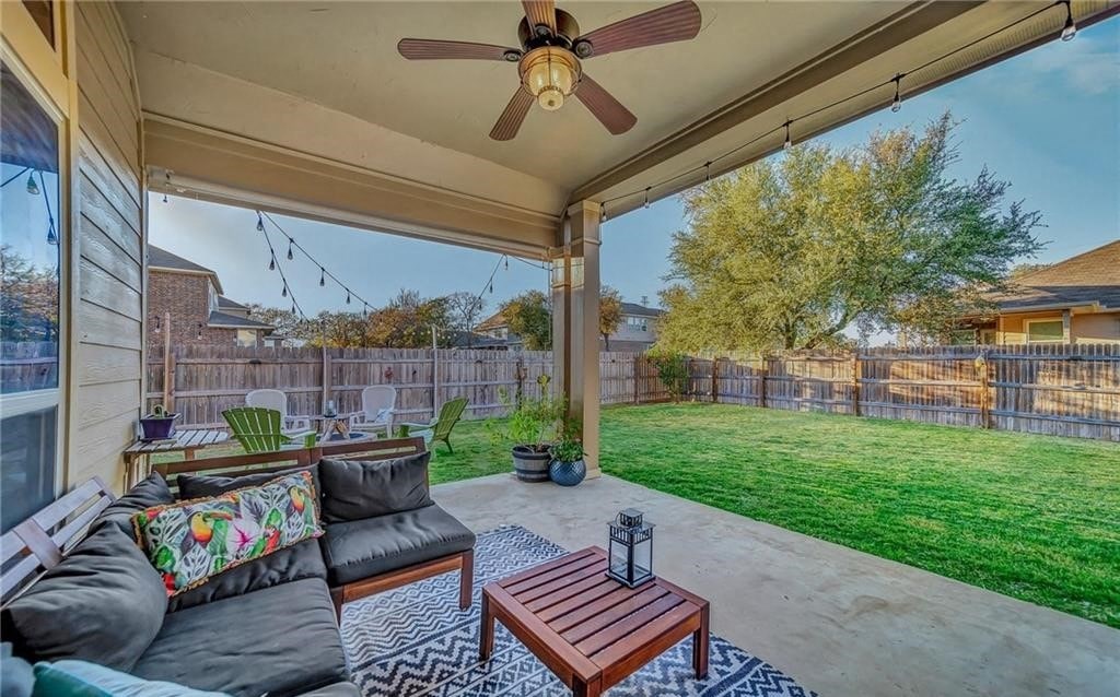 a covered patio with a ceiling fan and a sliding glass door