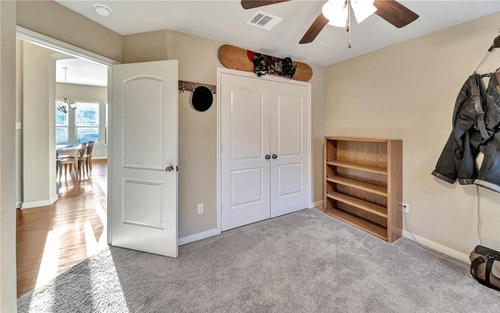 a living room with a ceiling fan and a closet