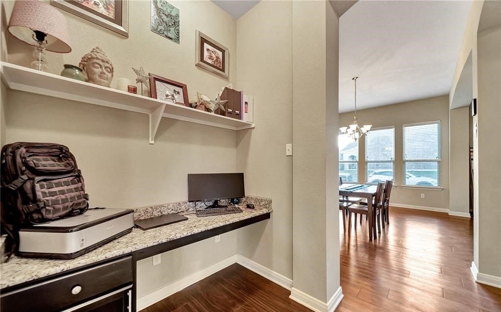 a home office with a computer and a desk and a window