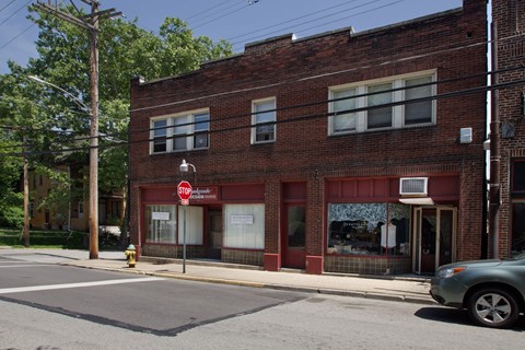 a red brick building on a street corner with a stop sign