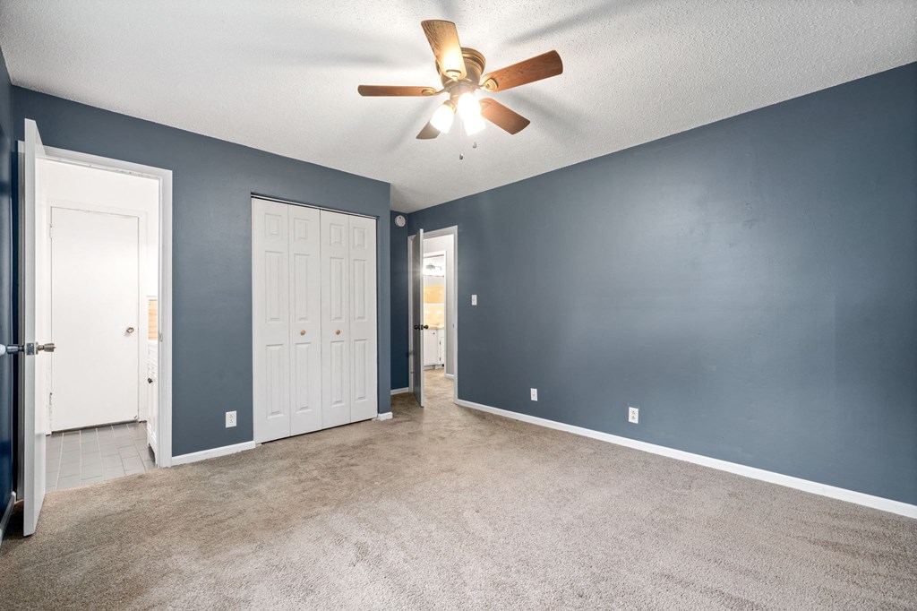 a living room with blue walls and a ceiling fan