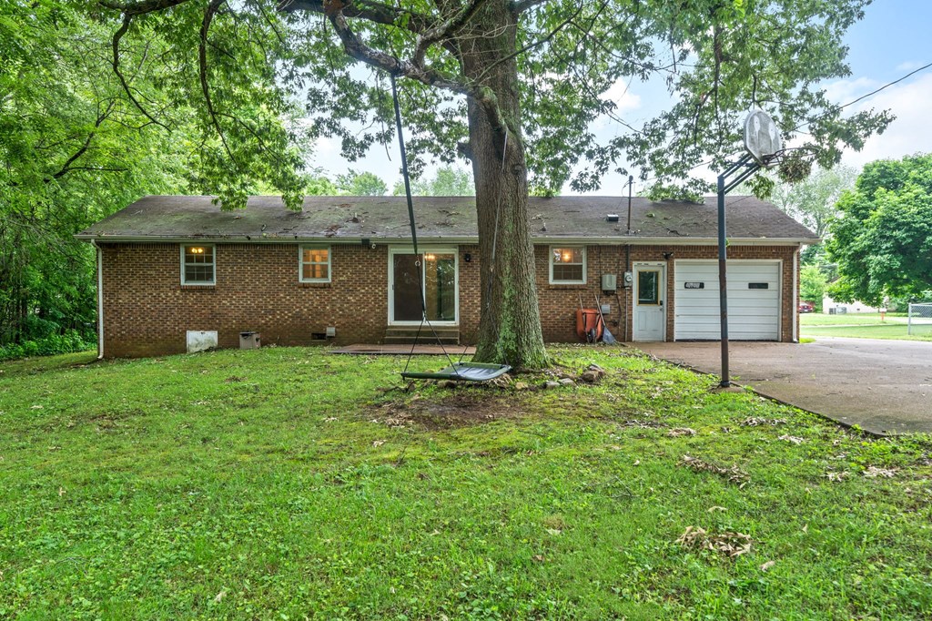 a small brick house with a tree in front of it