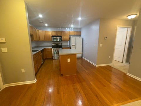 a kitchen with wooden floors and a cabinet in the middle