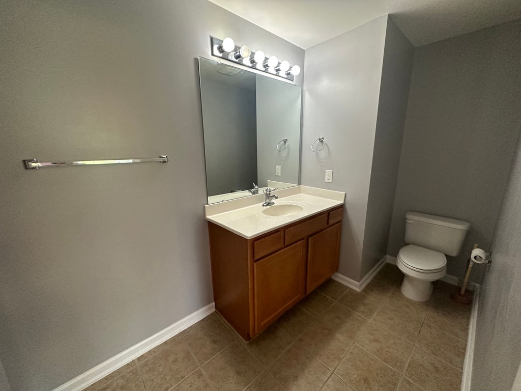 a bathroom with a sink toilet and a mirror