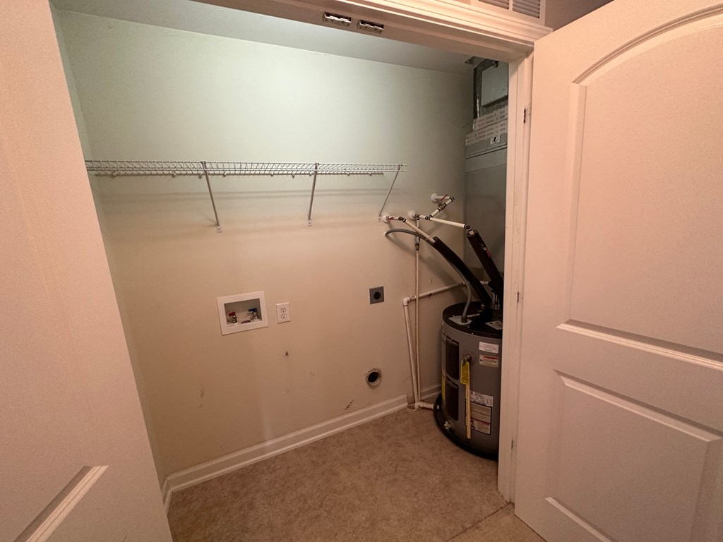 a room with a dryer and a closet with a door