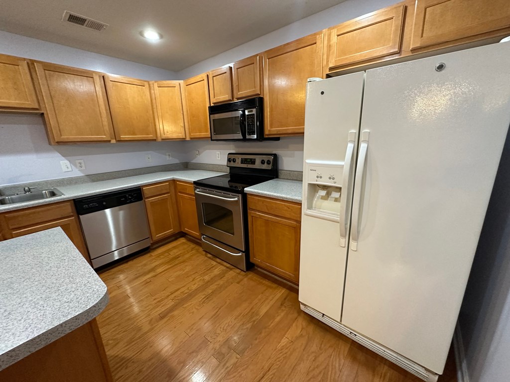 a kitchen with wooden cabinets and stainless steel appliances