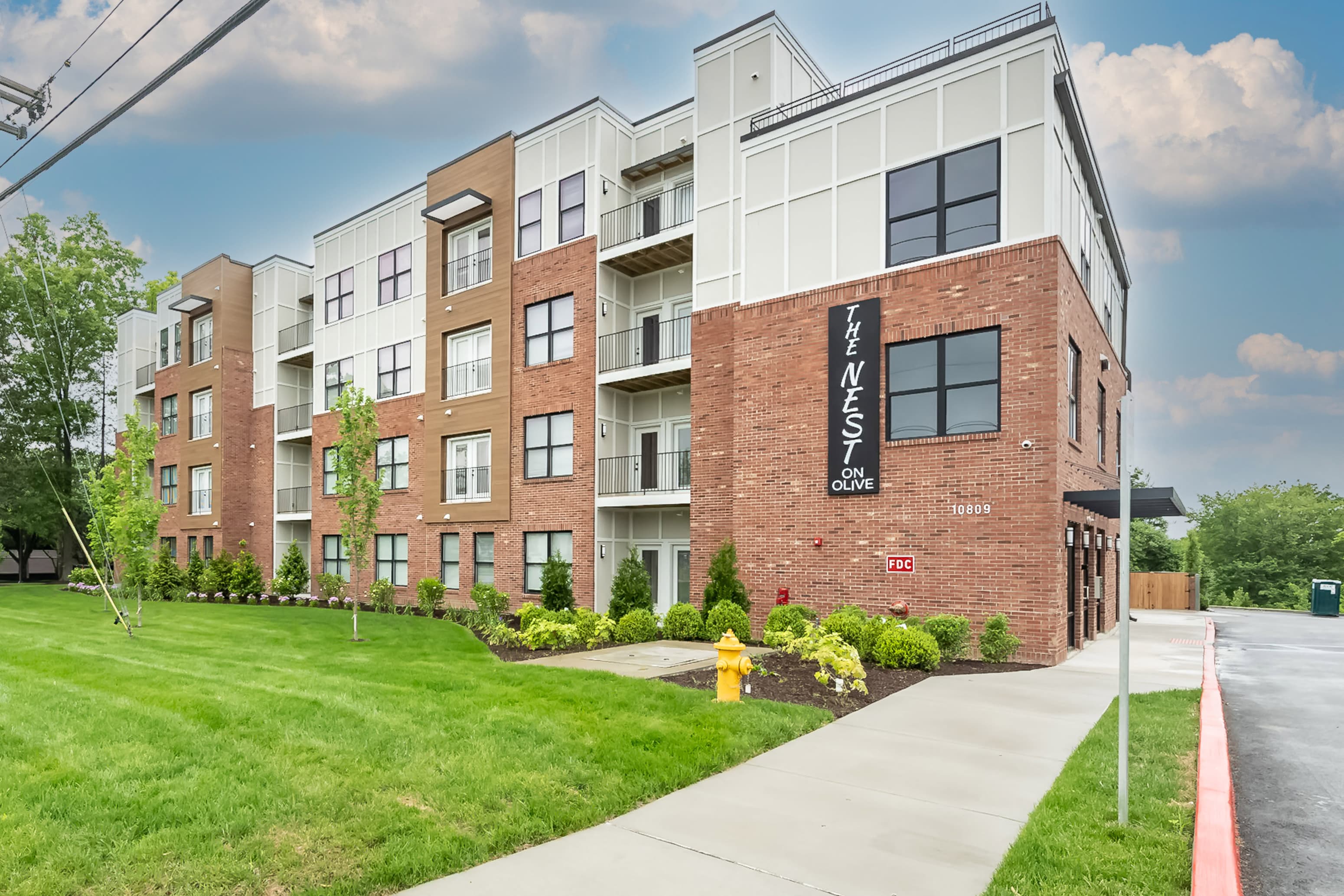 an apartment building with a sidewalk in front of it