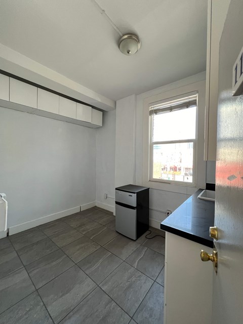 A room with a window, a door, and a counter.