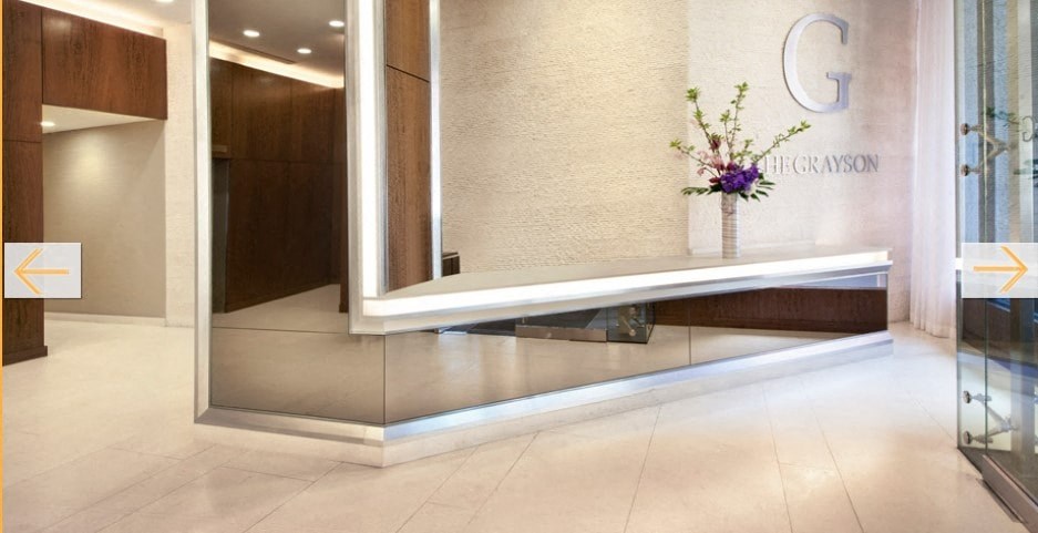 a lobby with a vase of flowers in front of a reception desk