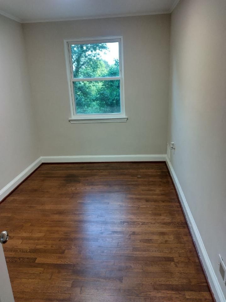 a empty room with a window and wooden floors