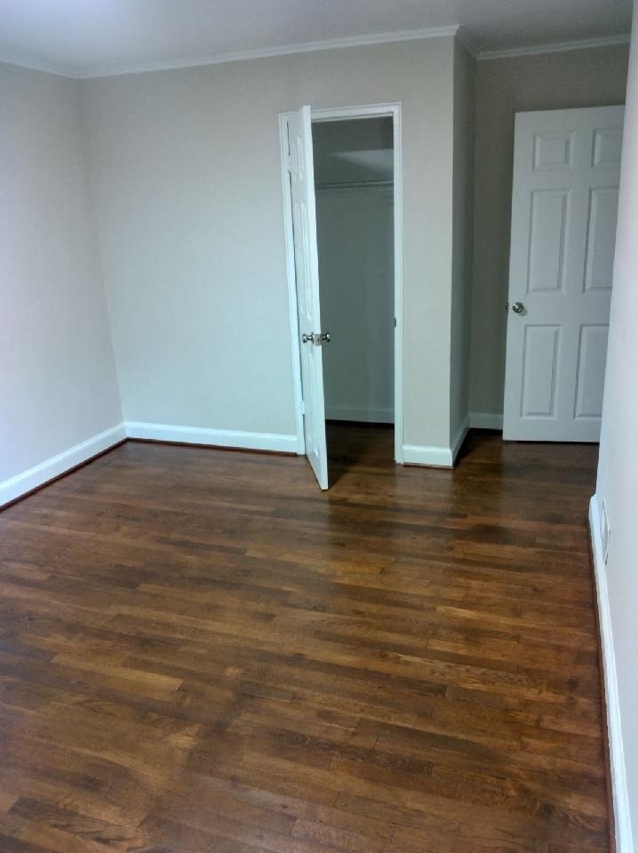 a room with a hard wood floor and a white door