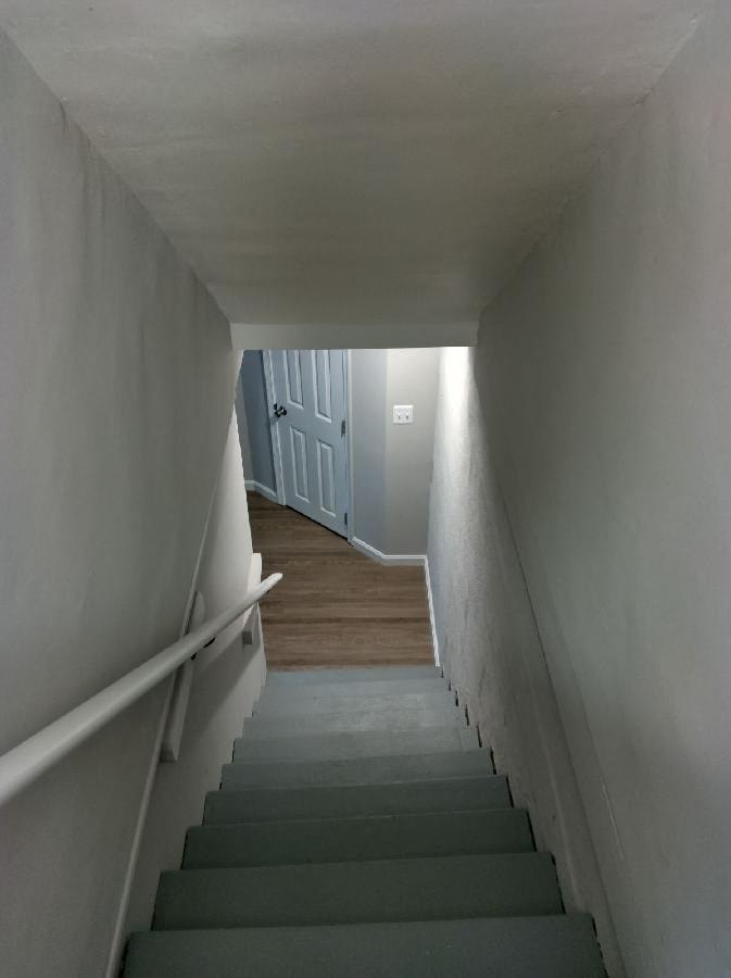 a flight of stairs with a blue door at the bottom