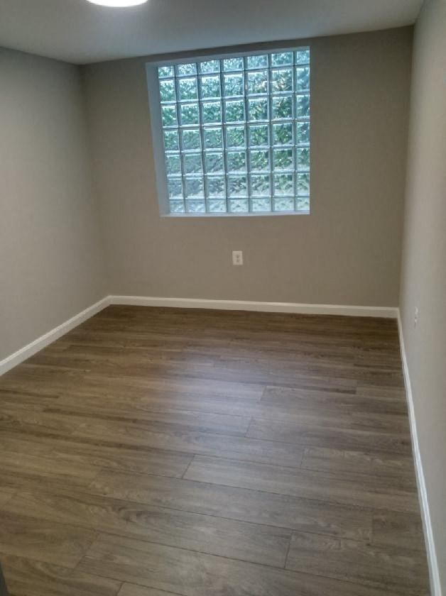 a empty room with wooden floors and a window