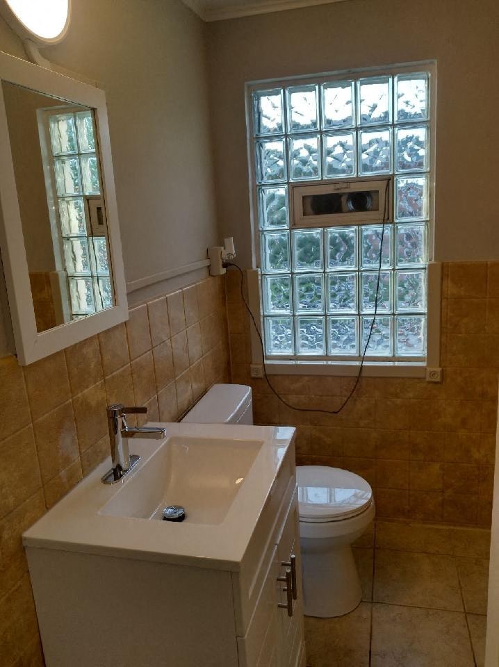 a bathroom with a toilet and a sink and a window