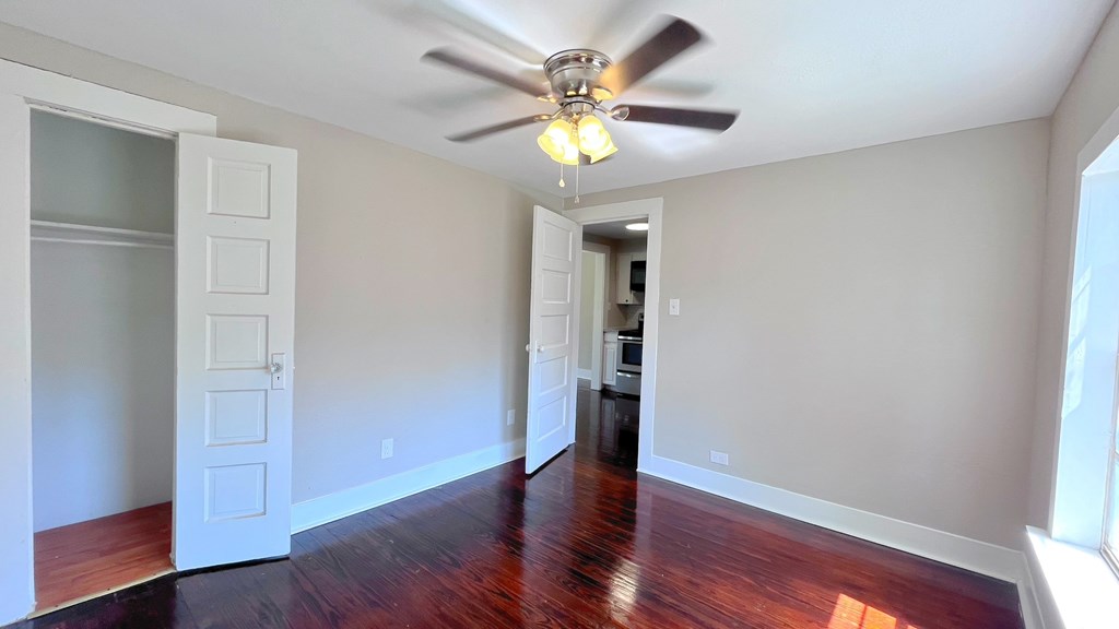 an empty living room with a ceiling fan