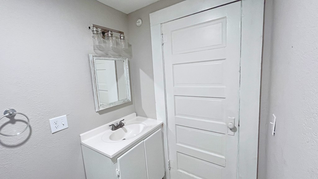 a small bathroom with a sink and a white door
