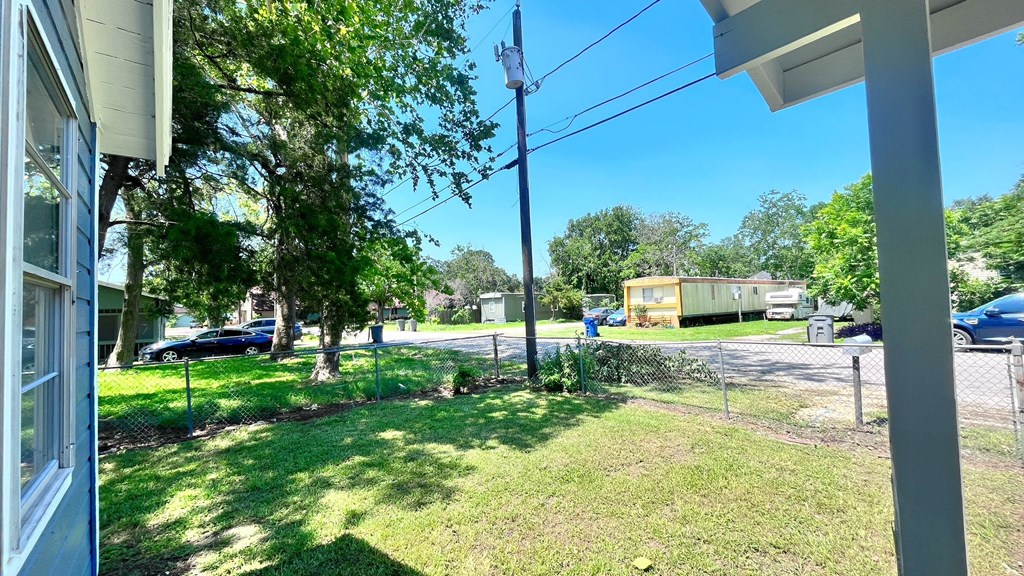 a view of the yard of a house with a chain link fence