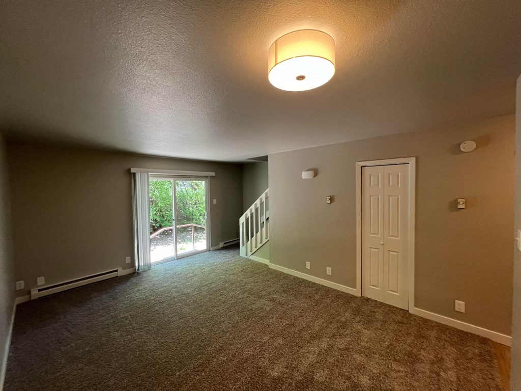 an empty living room with a door to a patio