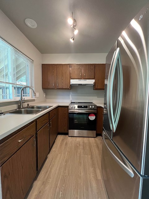 a kitchen with stainless steel appliances and wooden cabinets