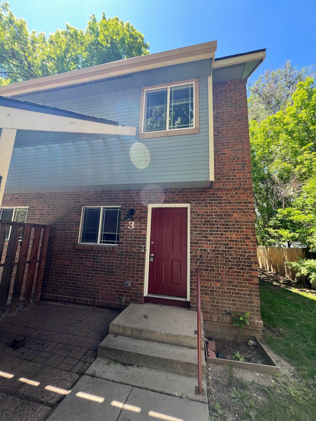 the front of a brick house with a red door