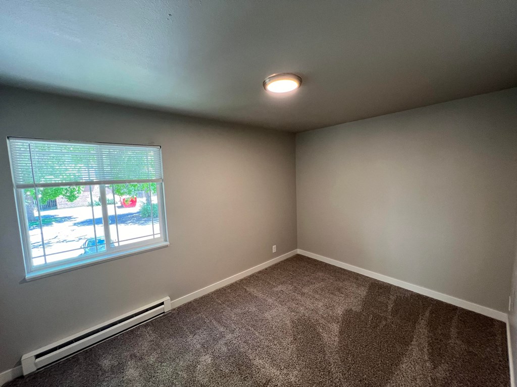 an empty room with carpet and a window