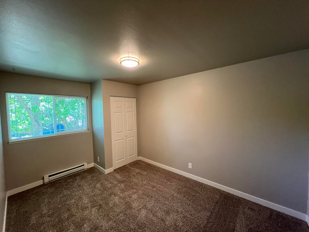 a empty room with carpet and a window