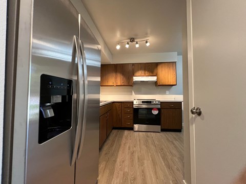 a kitchen with stainless steel appliances and wooden cabinets
