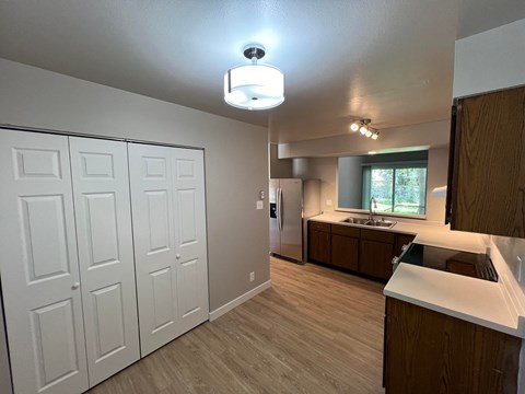 a kitchen with white cabinets and a sink and a refrigerator