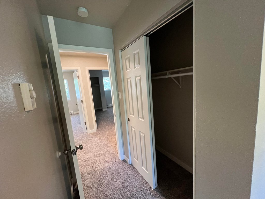 a bedroom with a closet and a door open to a hallway