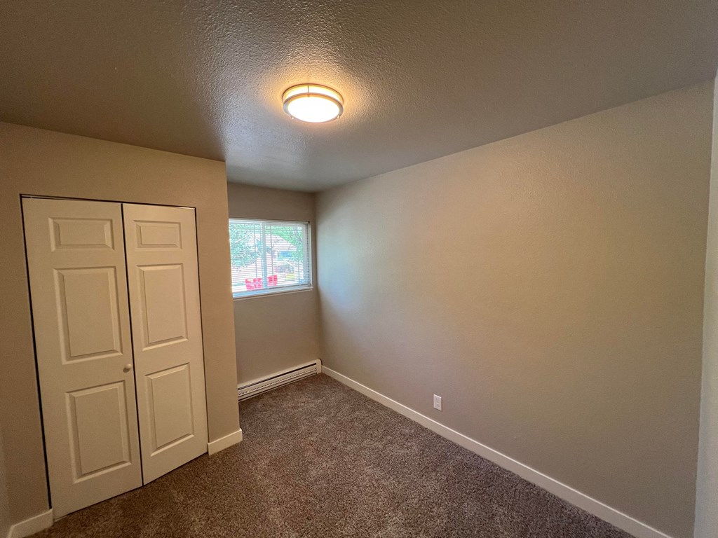 a bedroom with a closet and a window and a door