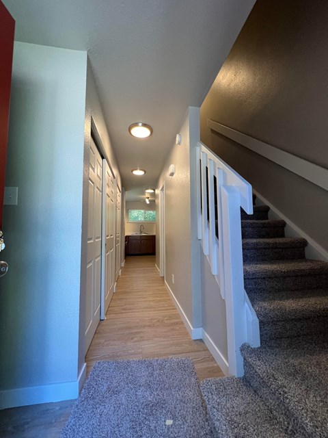 a look down the hallway of a house with stairs