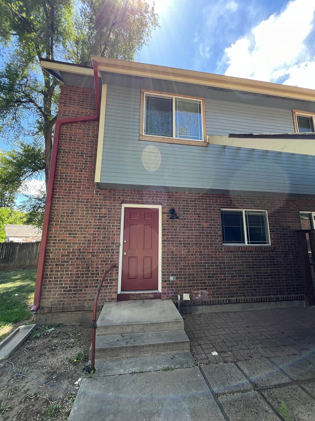 the front of a brick house with a red door