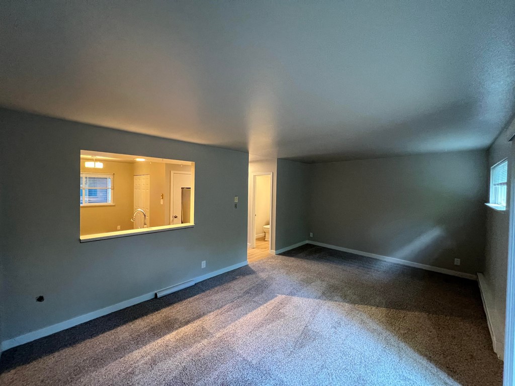an empty living room with a large mirror in it
