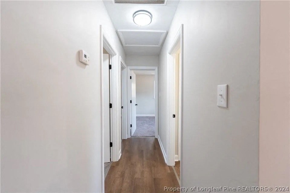 a renovated hallway with white walls and wood floors