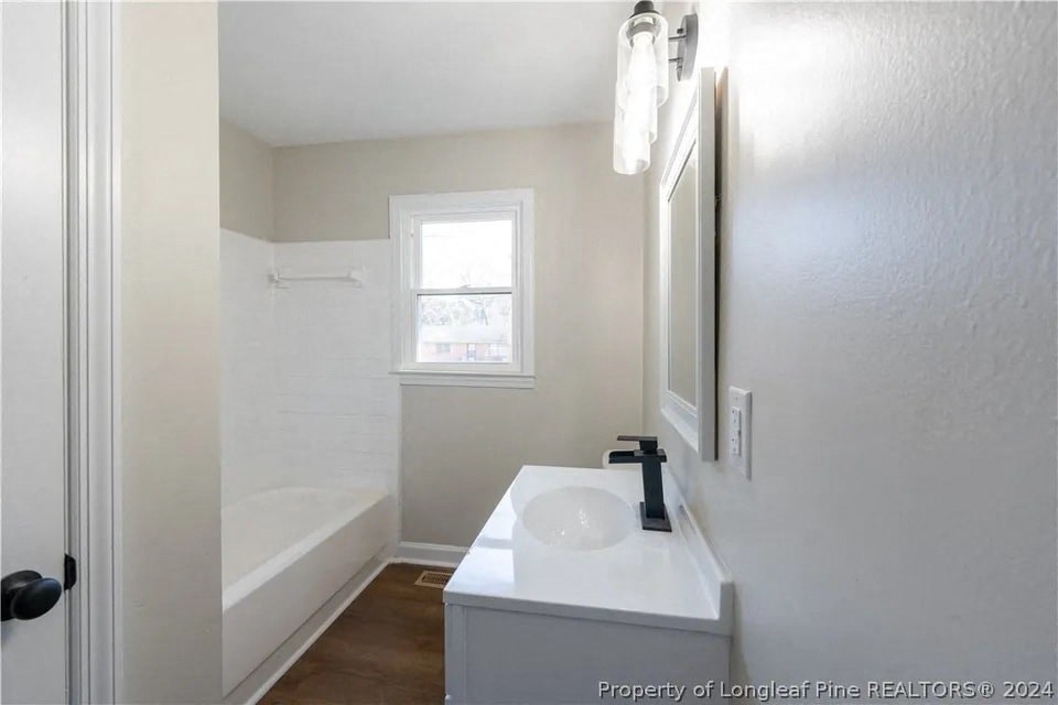 a bathroom with a sink and a tub and a mirror