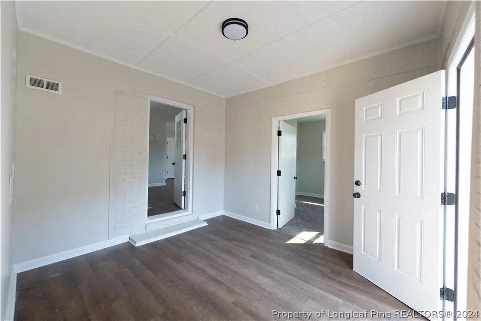 an empty living room with white walls and wood floors